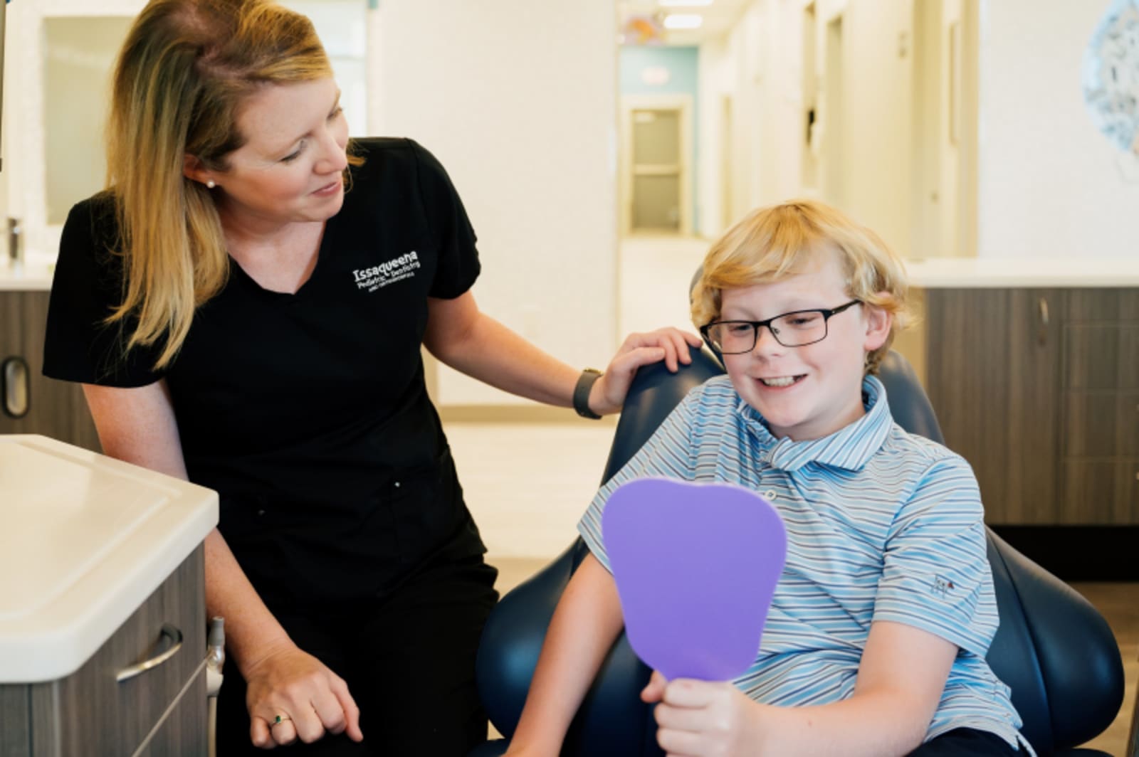 Pediatric dentist with young child patient discussing treatment options in friendly setting