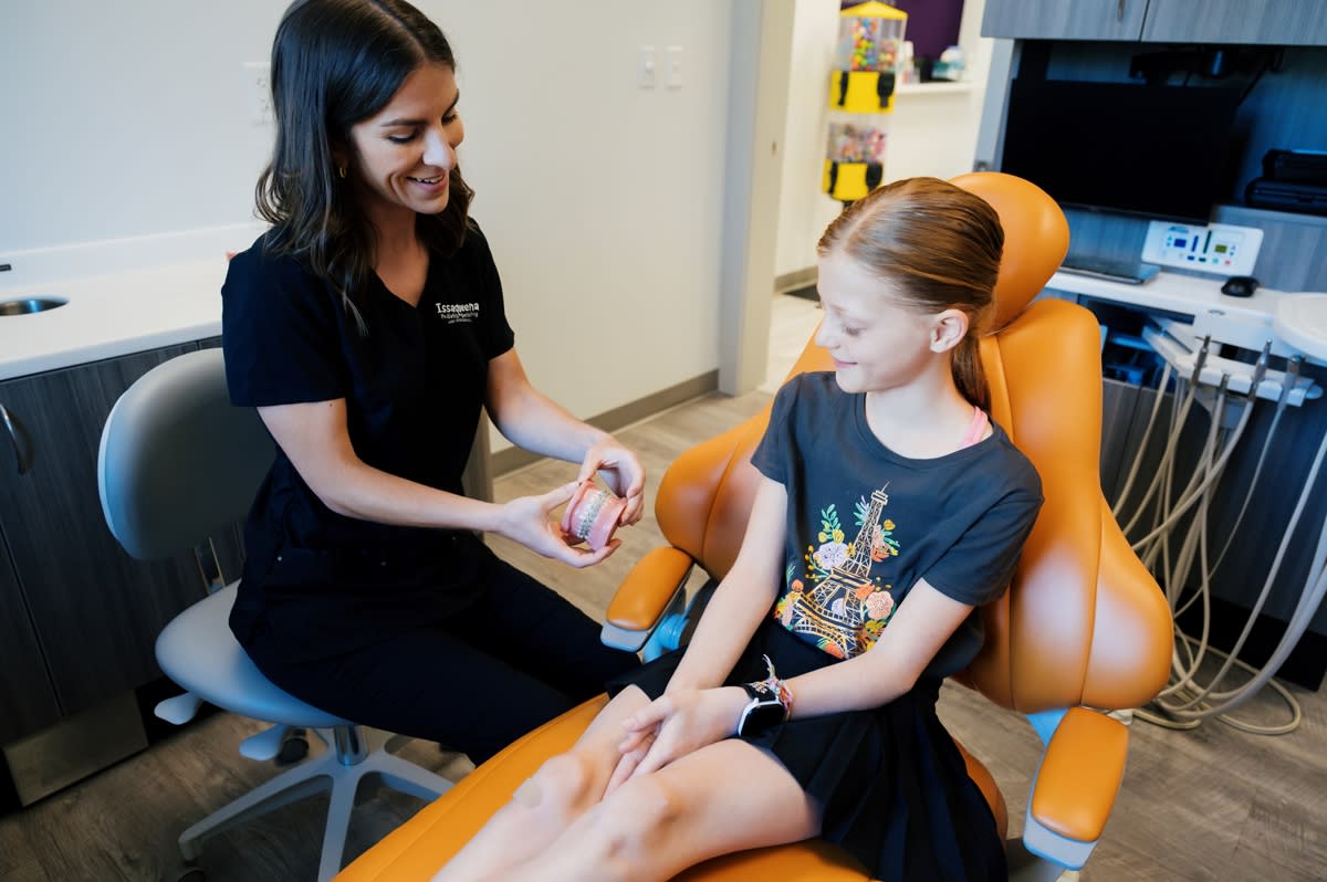 Dentist examining a young child's teeth during a dental procedure