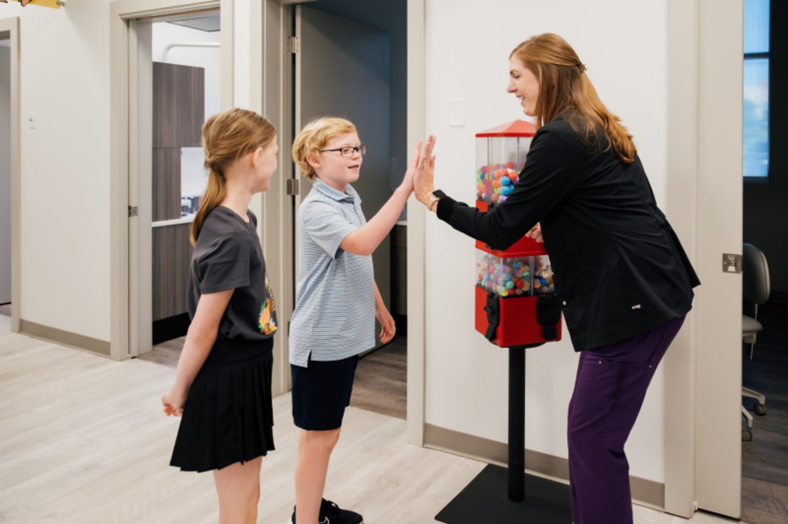 Dental hygienist greeting young patients at the office entrance