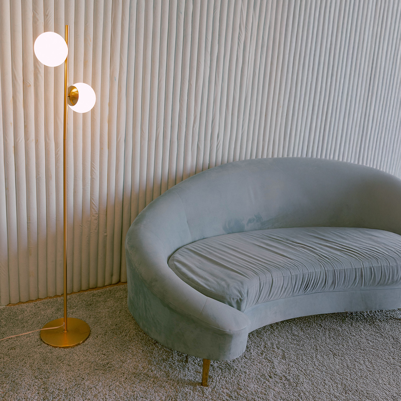 Blue couch in a blue room with a floor lamp