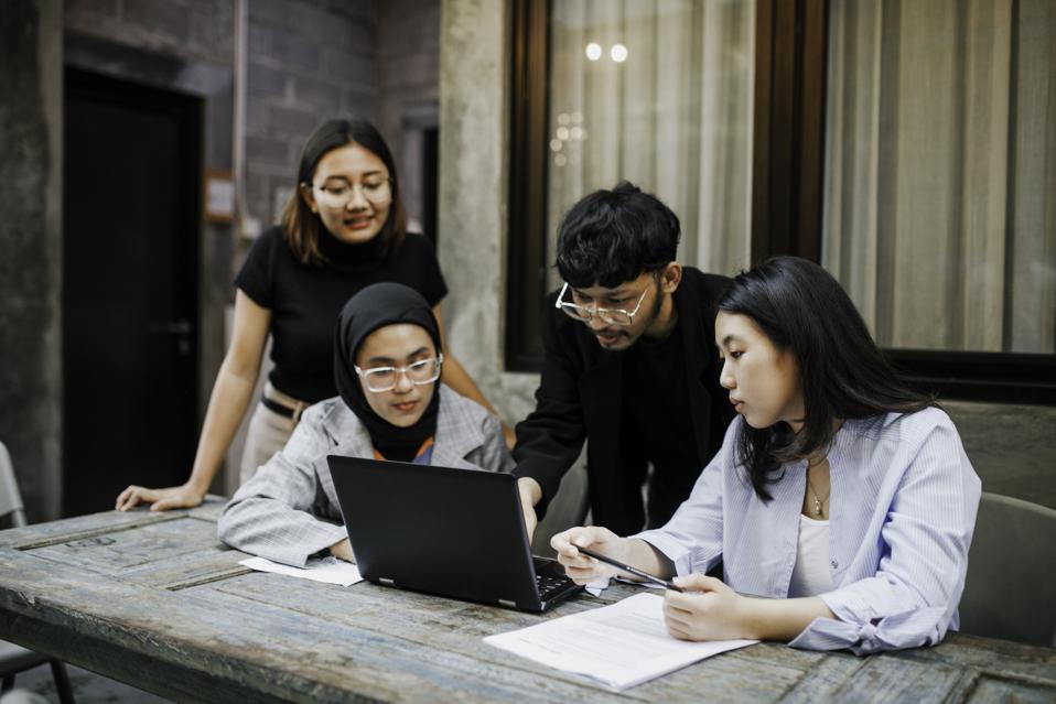 Community college students collaborating in a modern computer lab with AI and technology training equipment