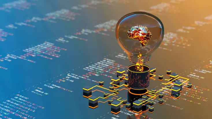 Photo of a lightbulb sitting on top of a computer screen where code is displayed