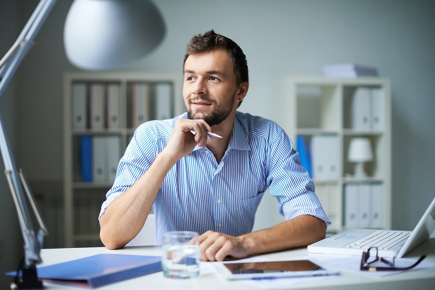 Photo of a man brainstorming behind a table