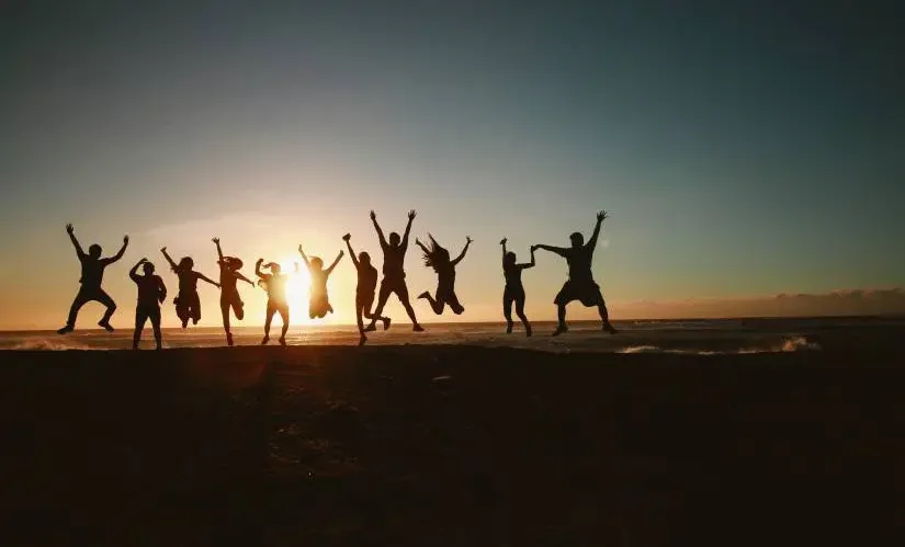 Photo of people jumping up during sunset