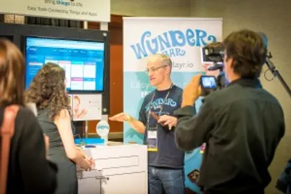 Photo of two people discussing behind a booth at an event