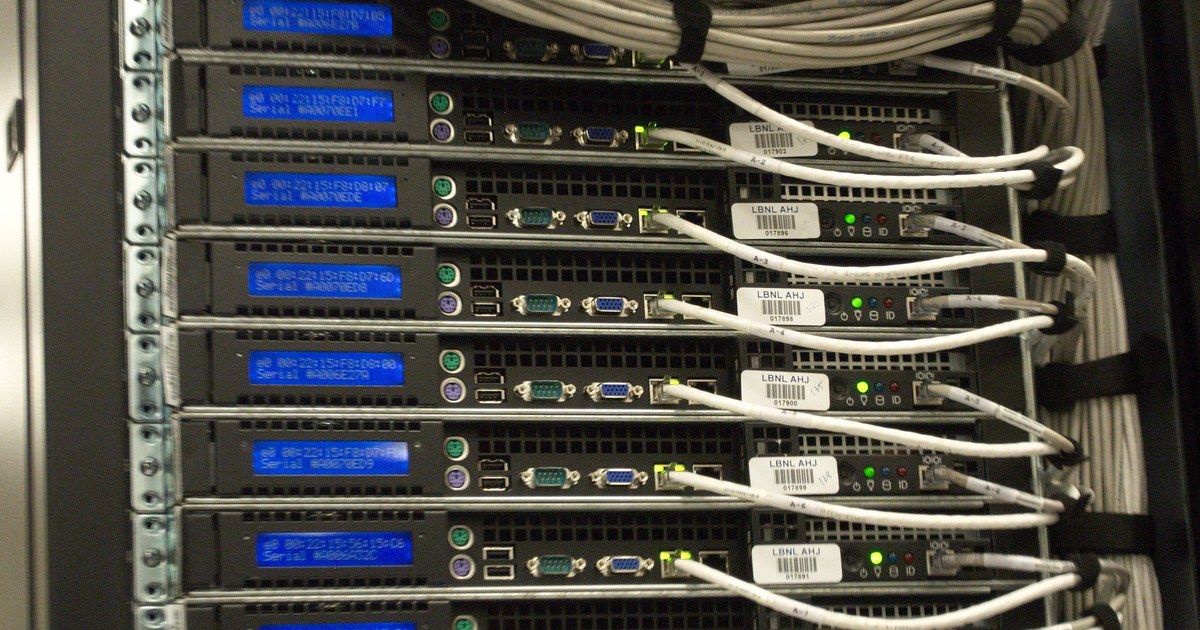 Rear view of a data center server rack with blue status lights, evoking the infrastructure behind the OpenAI/Hugging Face agent incident.