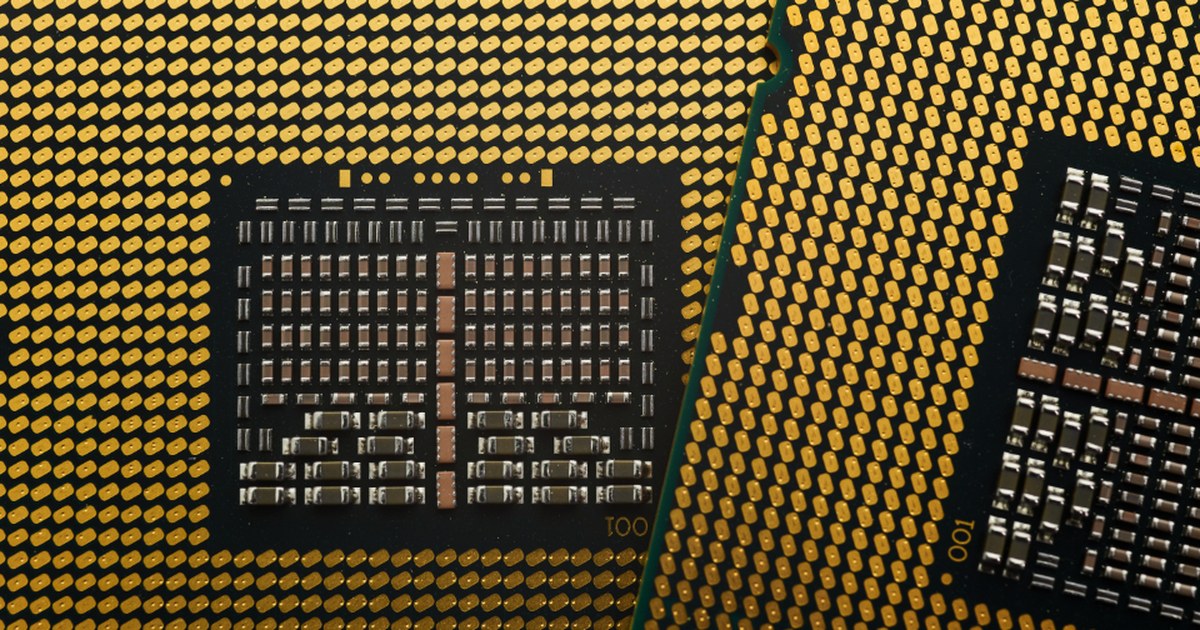 Macro photo of a gold-pinned computer processor chip, representing the AI infrastructure spending discussed alongside the St. Louis Fed's productivity research.