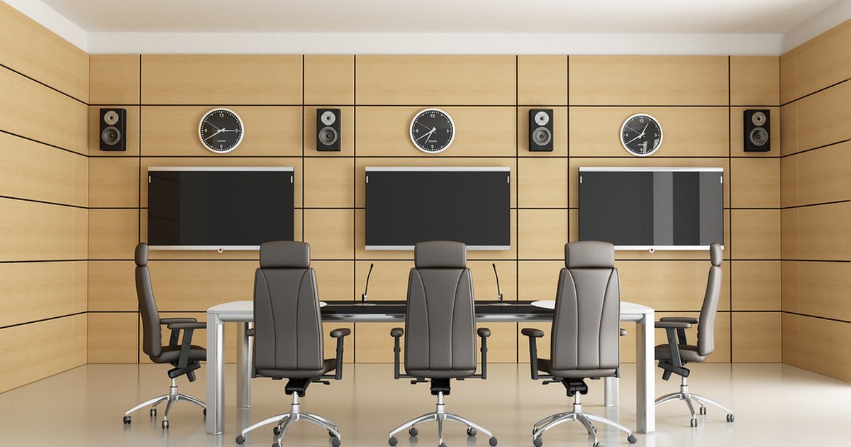 An empty modern conference room with a long table and monitors, representing the governance coalition formed by the Open Secure AI Alliance.