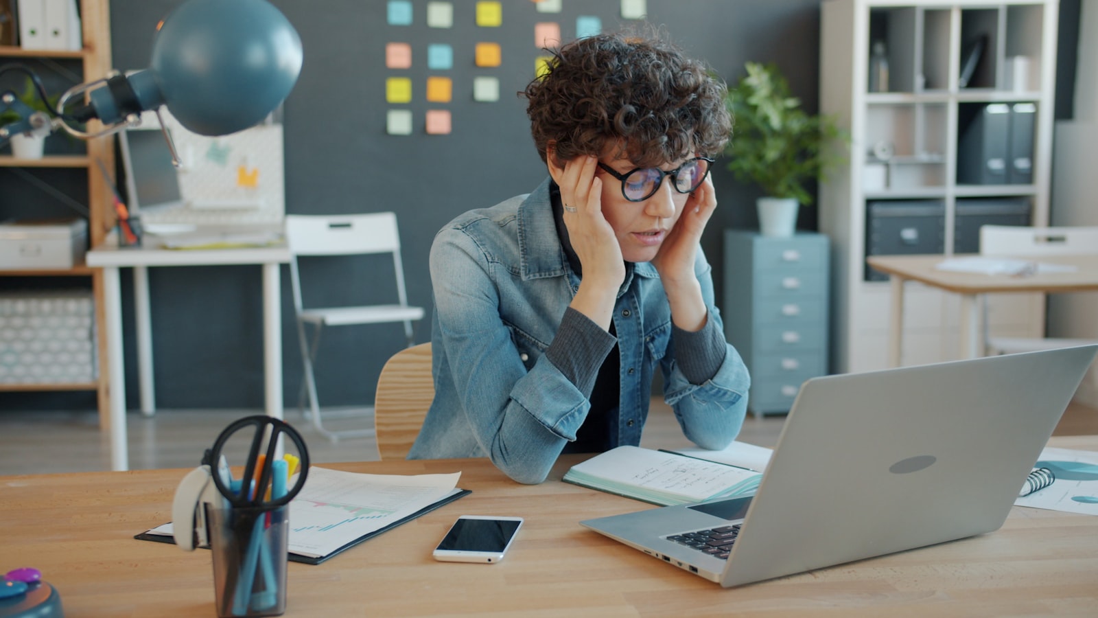 A person looking stressed while reviewing data on a laptop, representing the gap between AI agent spending and measurable business value