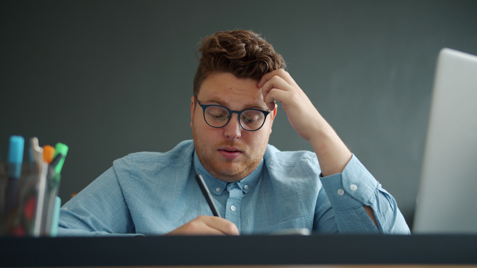 A stressed businessman working late at a laptop, representing the hidden burden AI adoption places on middle managers