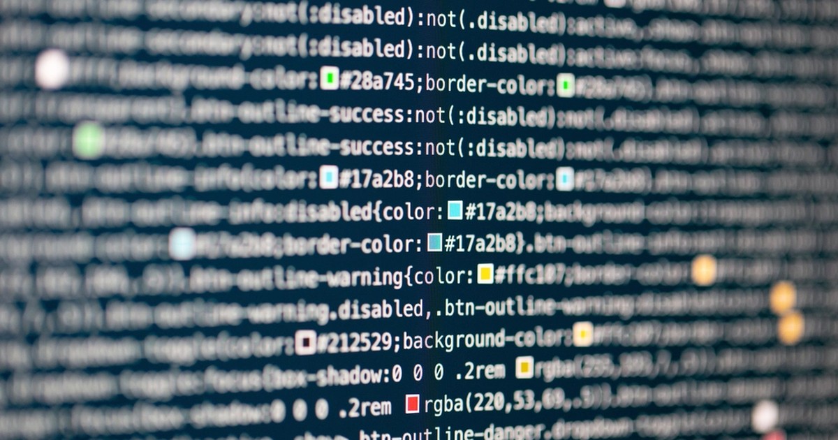 Extreme close-up of blue-toned CSS code on a computer screen, with colorful syntax-highlighted lines fading out of focus in the background.