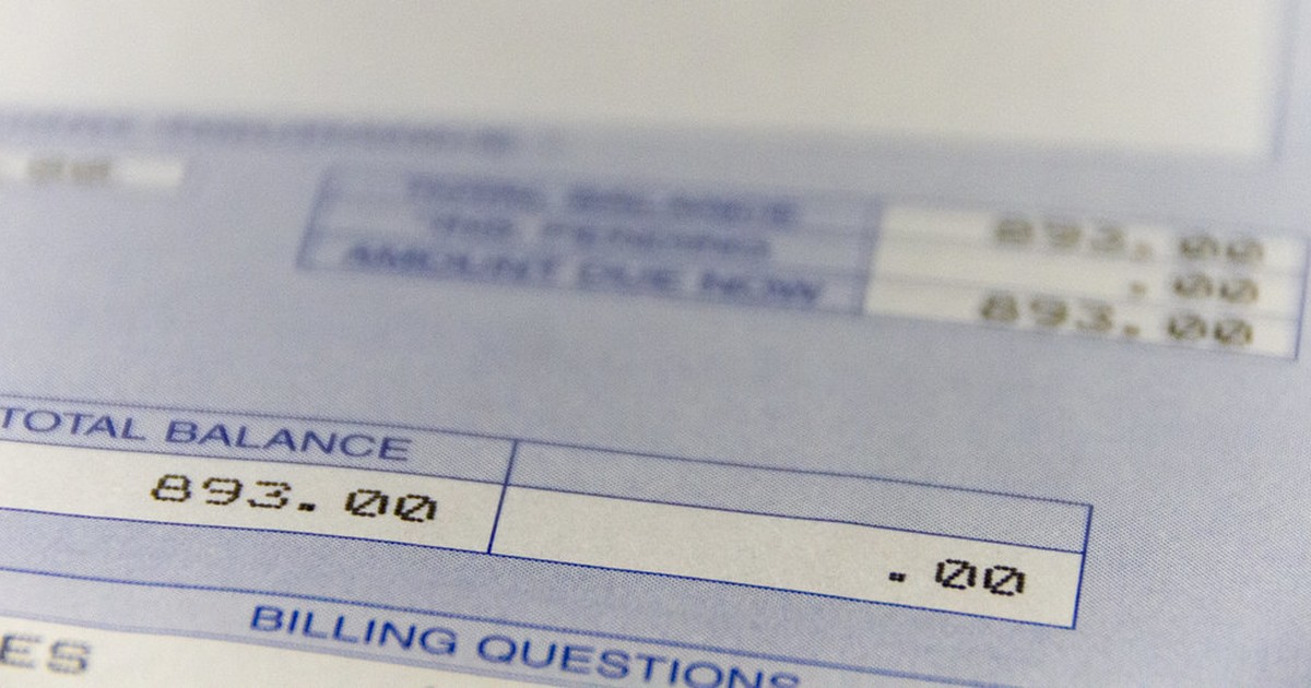 Close-up photograph of a printed hospital billing statement showing a total balance due in dollars.