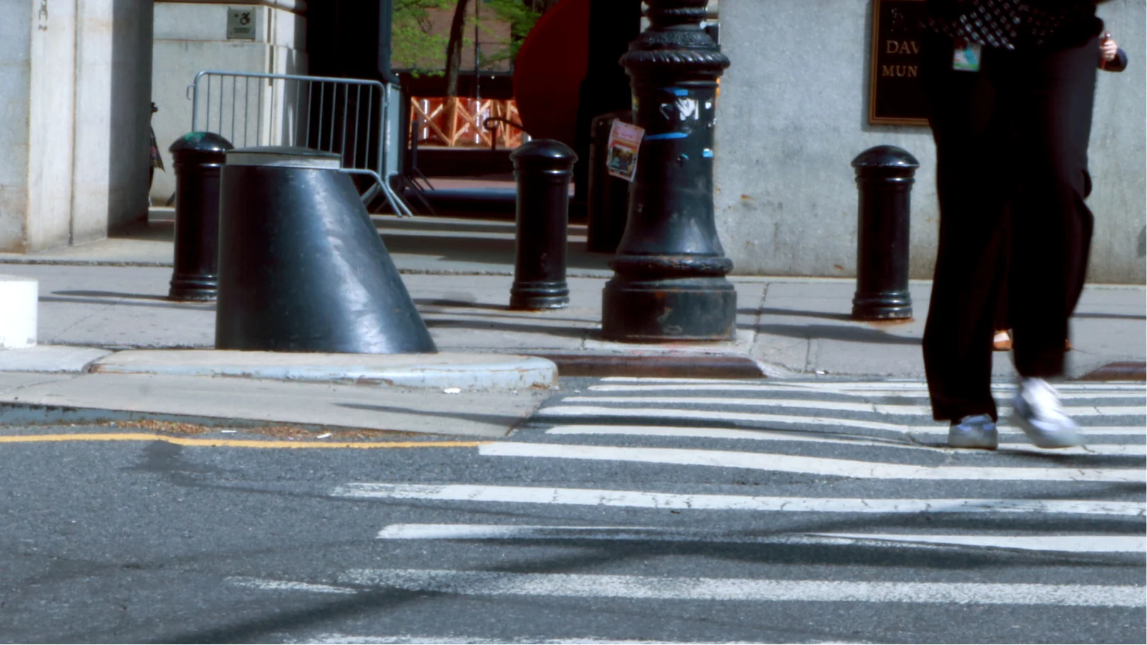 Pedestrian crossing past a cone bollard and post bollards