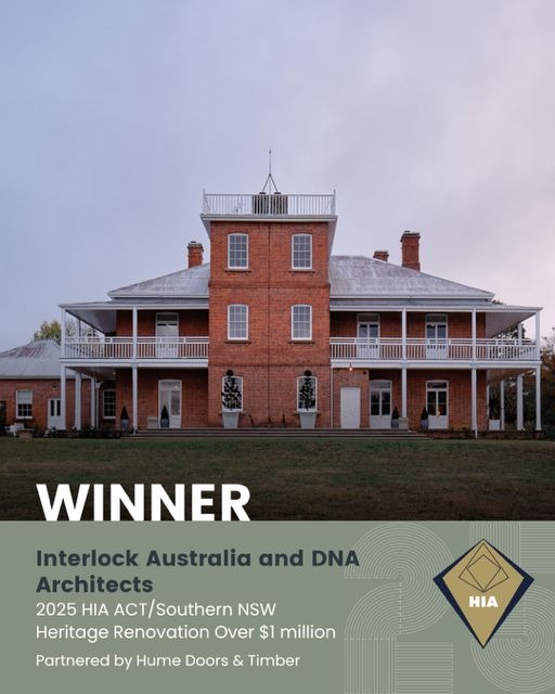 Large historic red brick heritage building with a central tower and wrap-around balconies under a gray sky, accompanied by text announcing the winner of the 2025 HIA ACT/Southern NSW Heritage Renovation Over $1 million award given to Interlock Australia and DNA Architects, partnered by Hume Doors & Timber.
