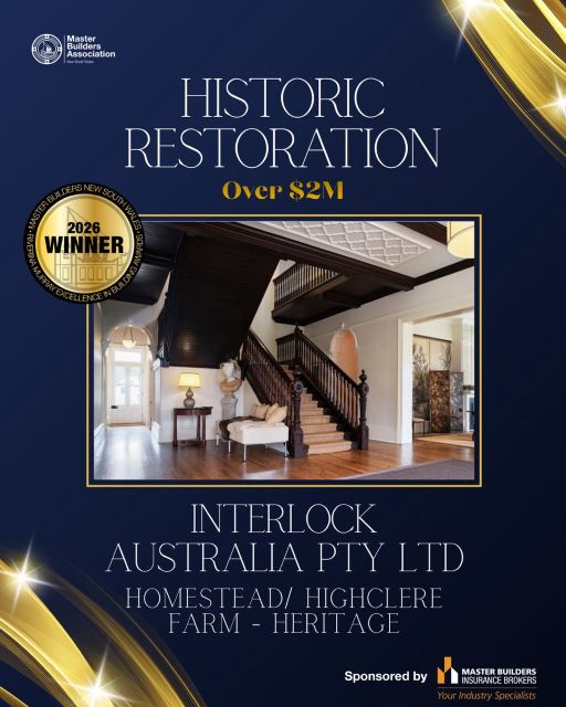 Award certificate from the Master Builders Association for historic restoration over $2M, won by Interlock Australia Pty Ltd for Homestead/Highclere Farm Heritage. The image includes a photo of an elegant interior with a dark wooden staircase, a white bench with cushions, a small table with a lamp, and classical decor. It has a navy blue background with gold accents and a 2026 winner gold seal.