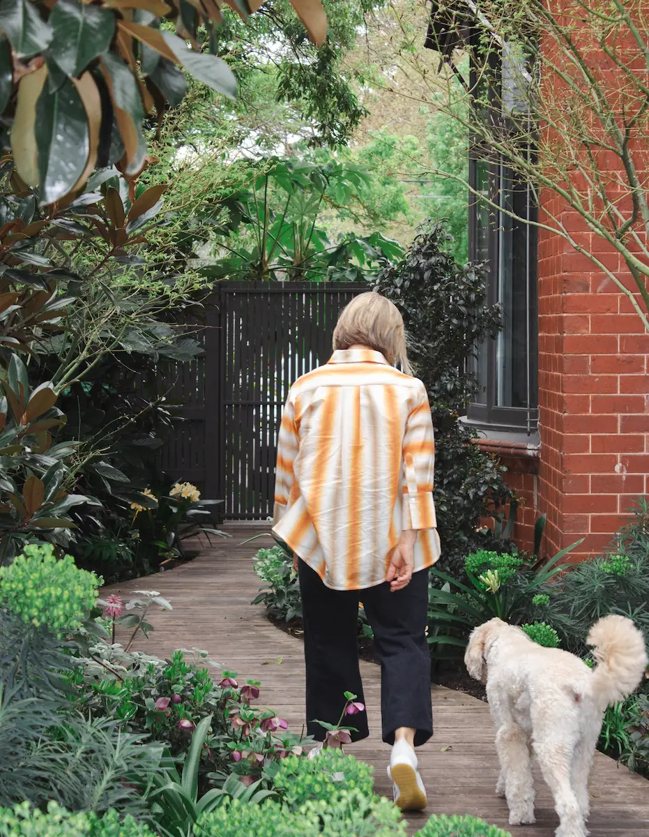 there is a woman walking a dog on a wooden walkway