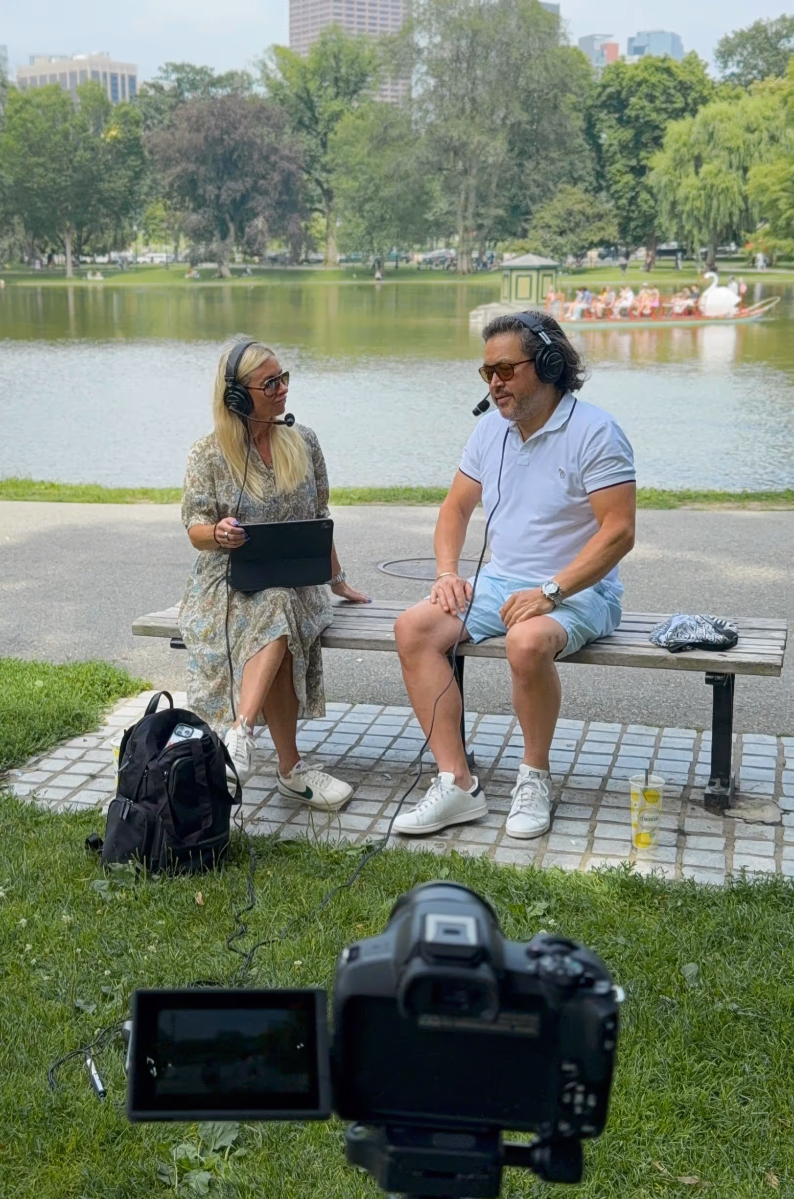 Mandy Dwight and a podcast guest chatting on a bench at a park.
