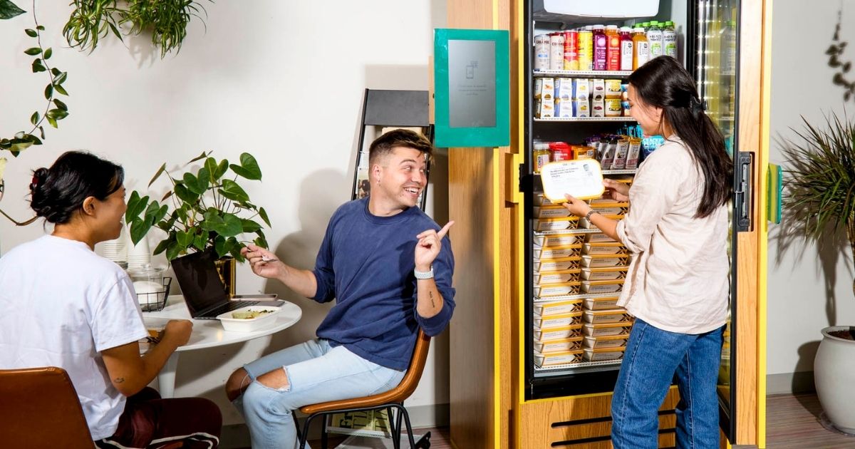 Smart fridge in a residential common area where residents are working and socializing