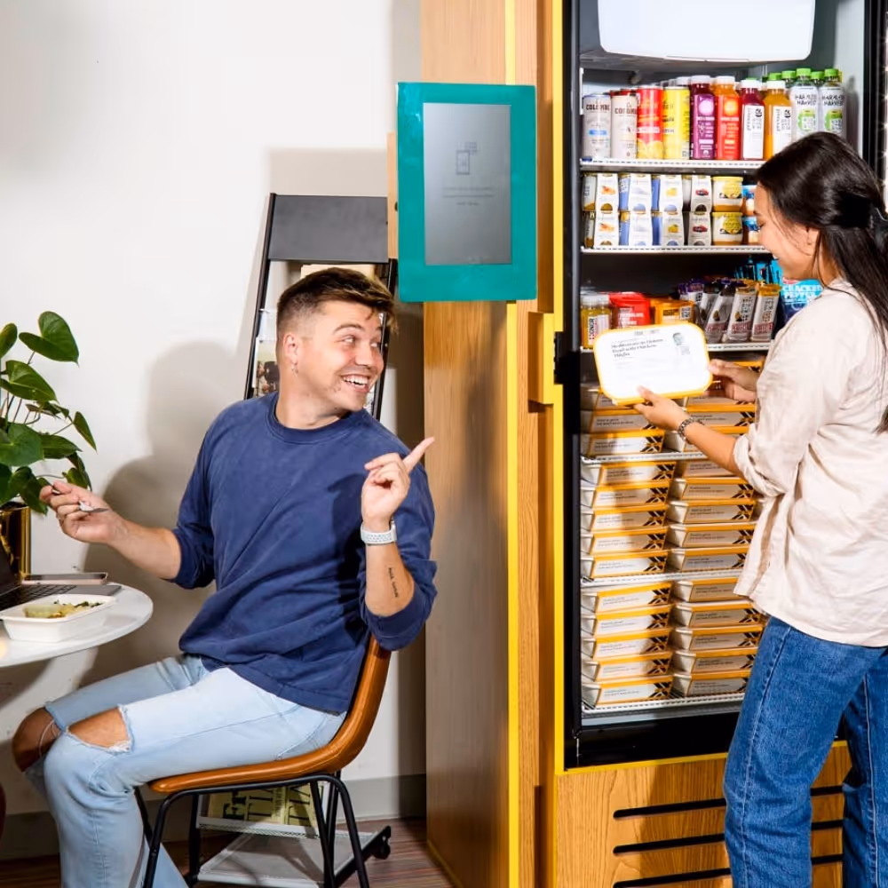 Residents using a smart fridge in a residential common area