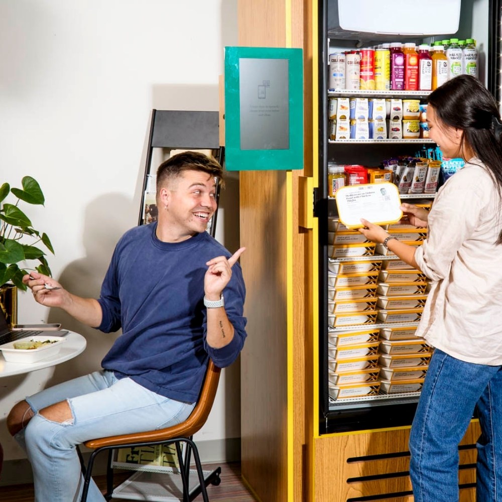 Residents using a smart fridge in a residential common area