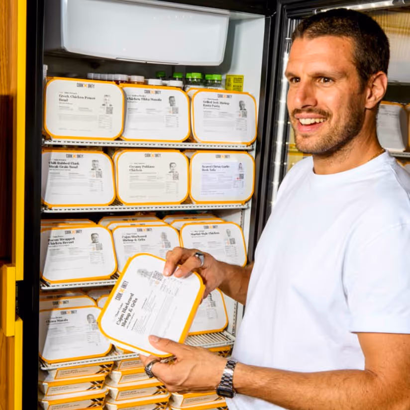 Employee taking a chef-made meal from a CookUnity Smart Fridge in the office