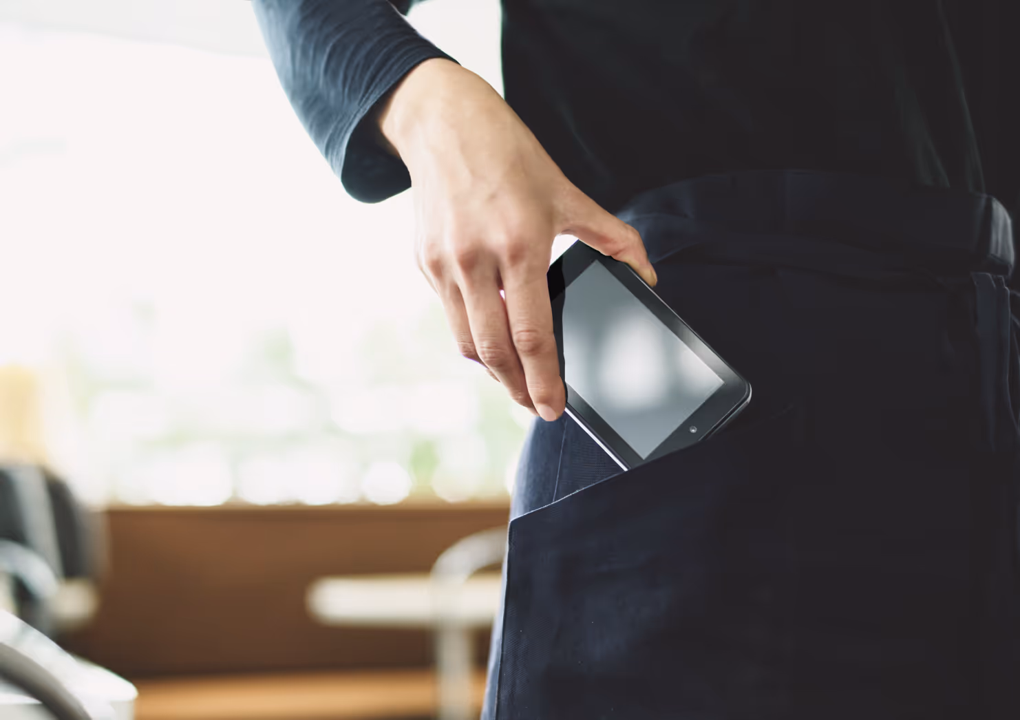 ポケットから決済端末を取り出している写真