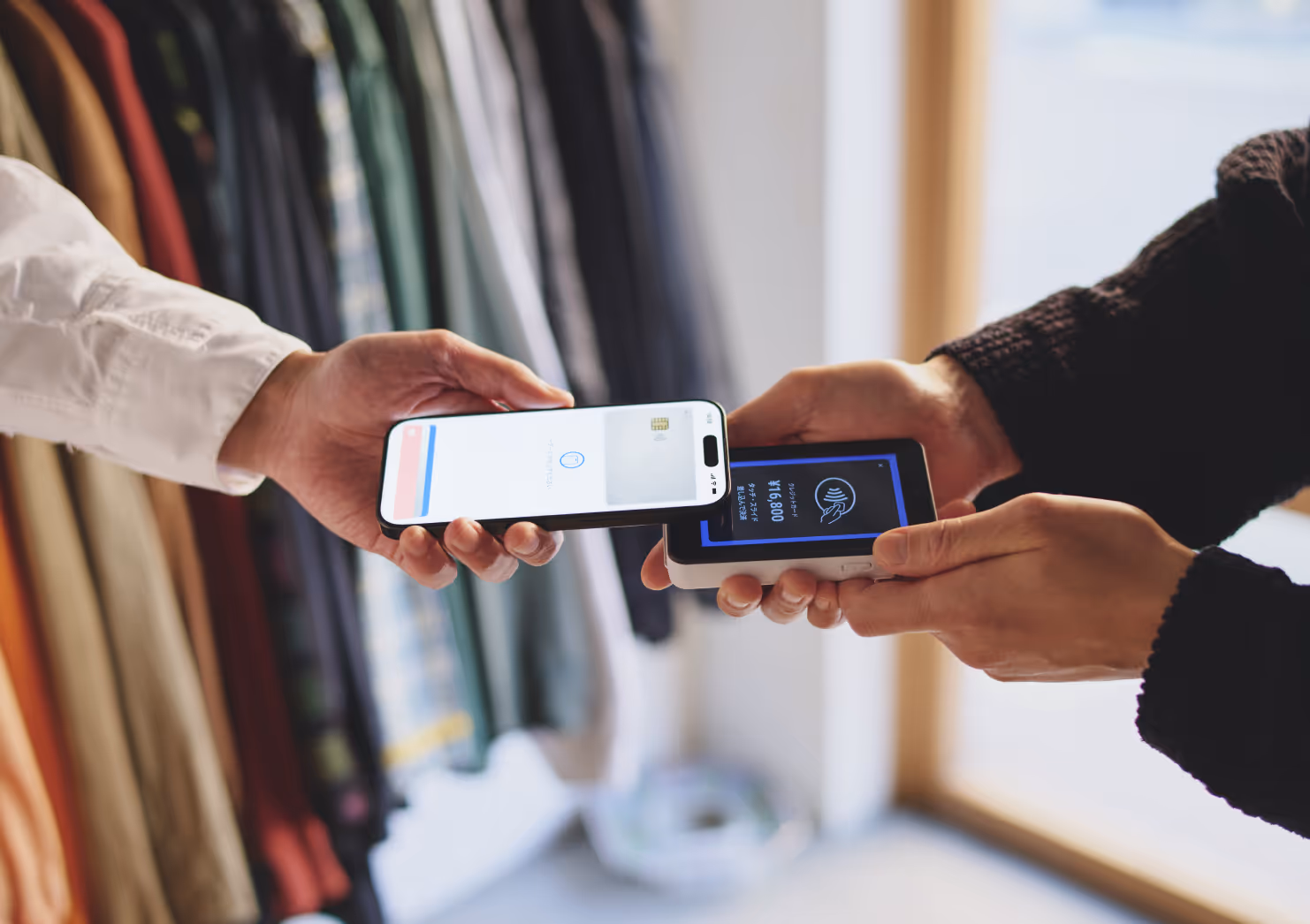 決済端末にスマホのクレカ決済をかざして決済している写真