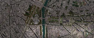 Aerial view of a densely built urban area featuring a river running through the center and multiple bridges connecting both sides.