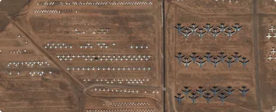 Aerial view of numerous decommissioned military aircraft arranged in rows on a dry, barren airfield.