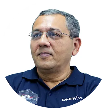 Middle-aged man with gray hair and glasses wearing a navy blue polo shirt with Dhruva logo.