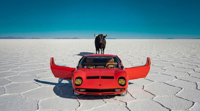 Lamborghini Miura face à un taureau sur un désert de sel, création par intelligence artificielle