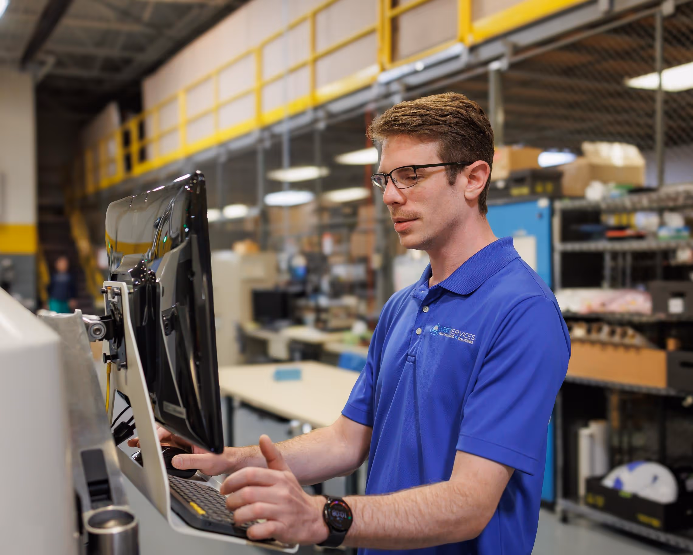 Leet Services IT technician operating industrial computer terminal in Rochester Hills managed services facility