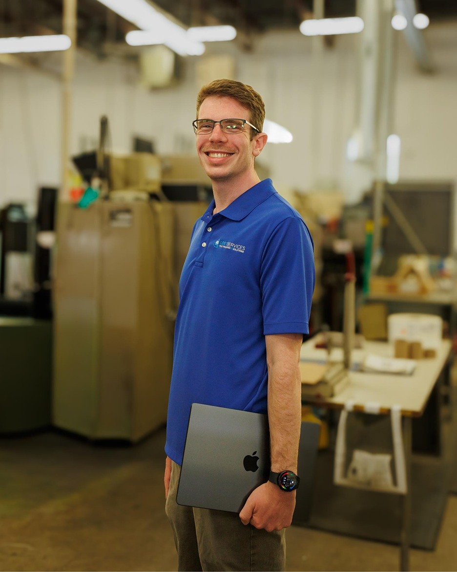 Leet Services IT technician holding MacBook laptop in Rochester Hills managed IT services facility