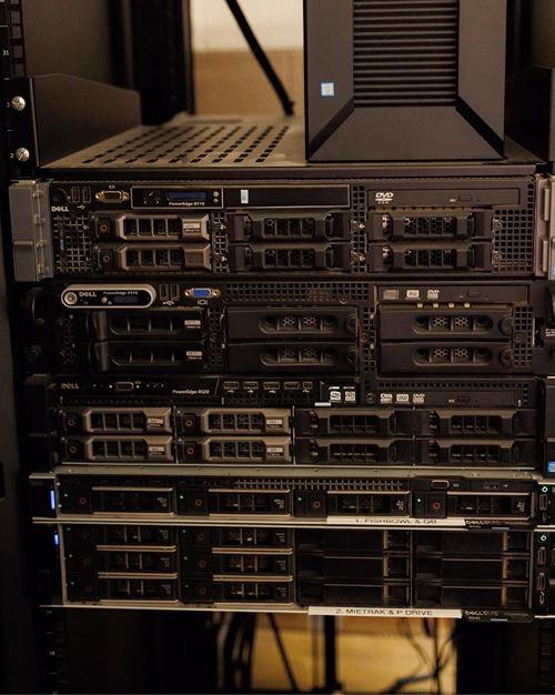 Dell PowerEdge rack-mounted servers in a data center server rack, including R710, 2970, and R520 models