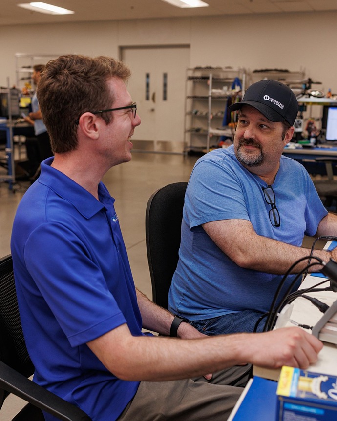 Two IT professionals collaborating at a workstation in a managed IT support office in Rochester Hills