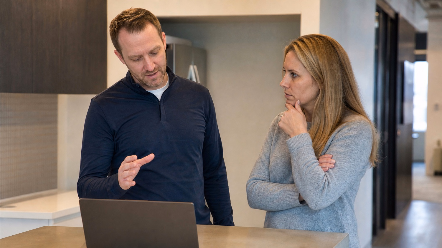 INFORMAL HUDDLE An IT professional two people standing and talking near a ki