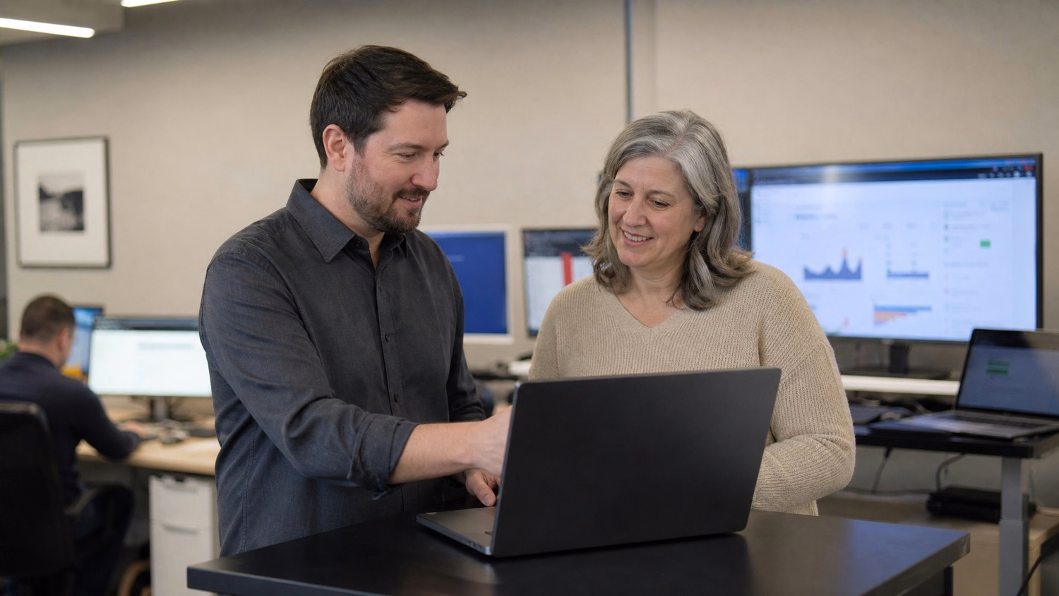 Couple reviewing simulated phishing email on laptop at standing desk