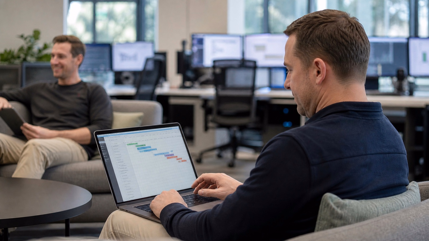 Man working on laptop Gantt chart IT upgrade lounge 63
