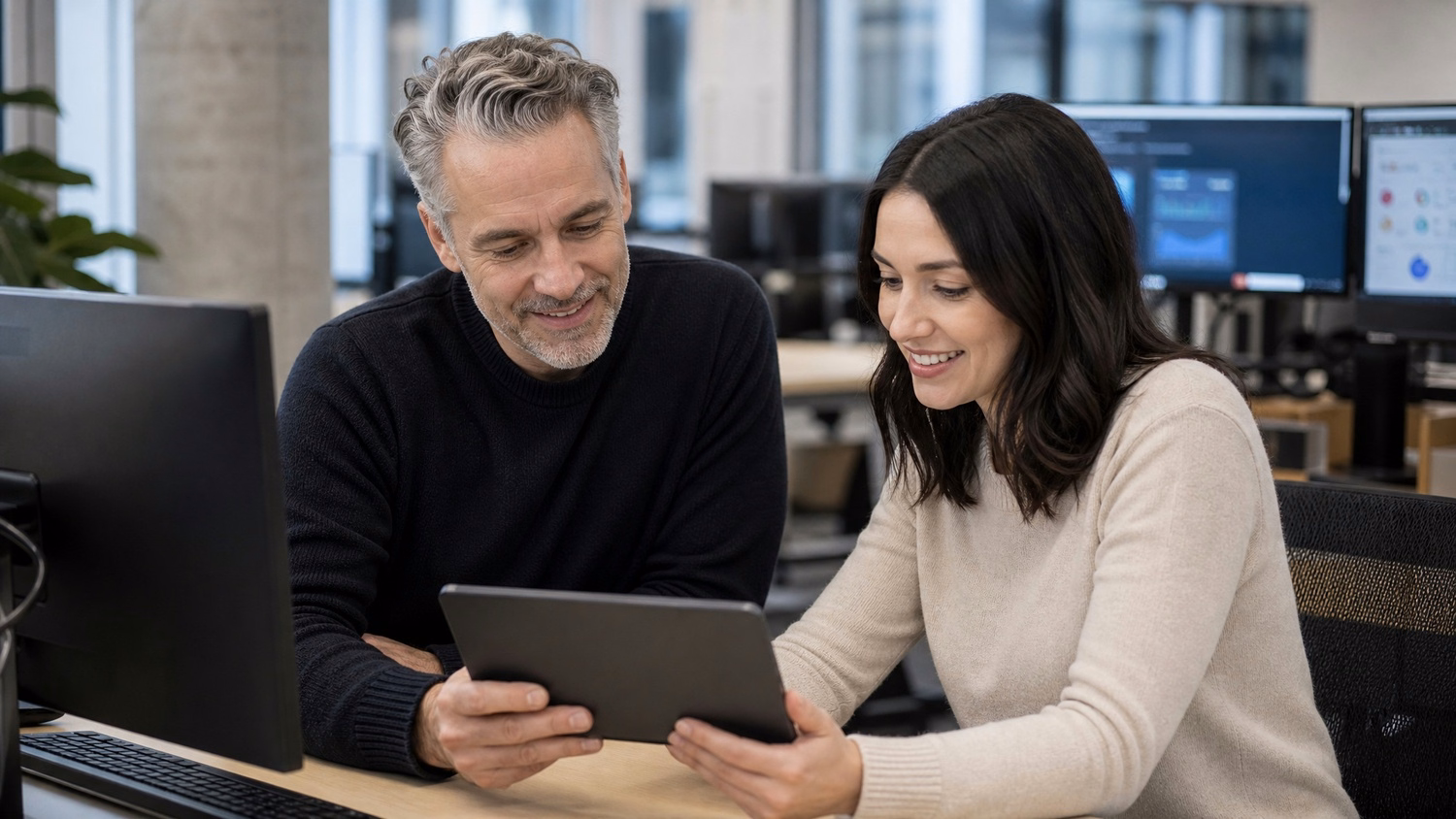 Two colleagues review data on a shared tablet screen