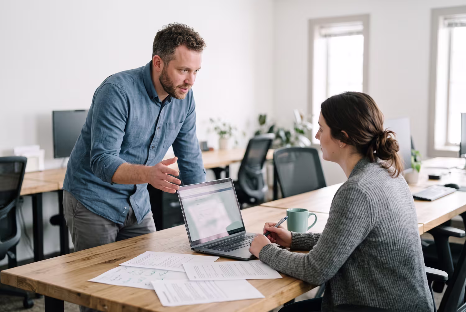 Two employees discussing password management best practices in office