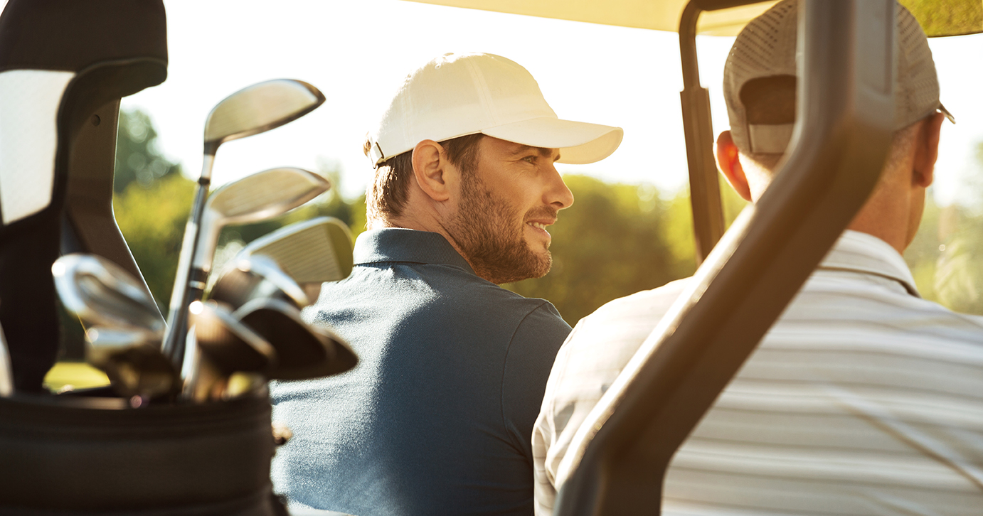 two male golfers riding a golf cart