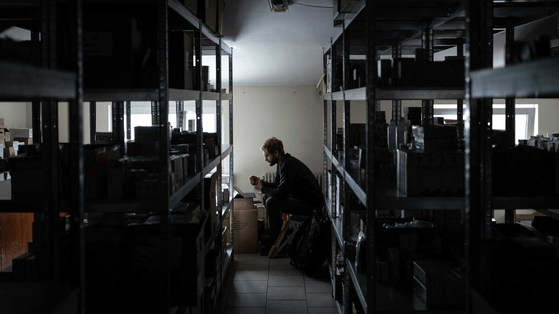 A Mission Kharkiv staff member works in the medicine storeroom during a power outage