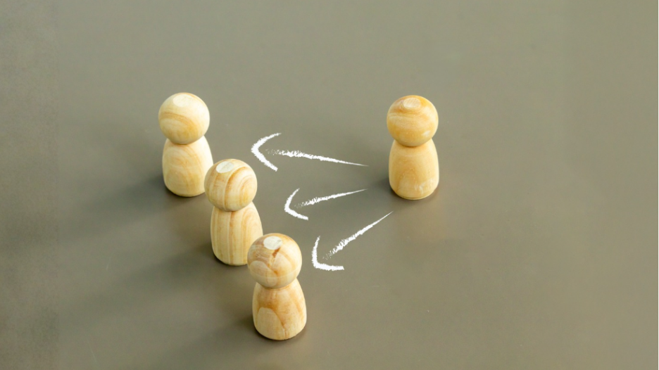 Wooden figures showing directional influence, representing influence and persuasion in leadership 