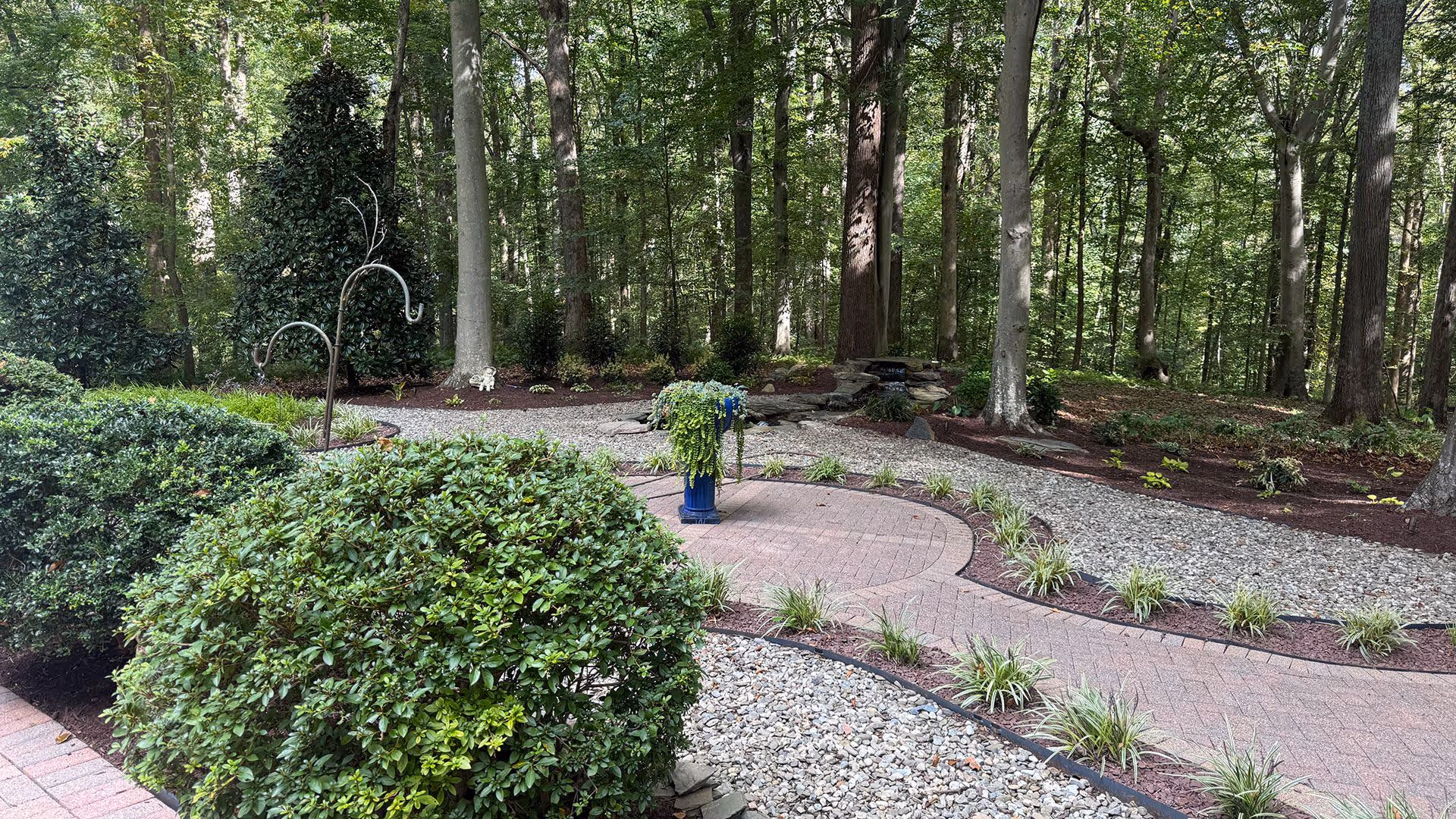 Beautiful backyard garden with patio pavers, new mulch and plants by Larsen's Lawn and Landscape.