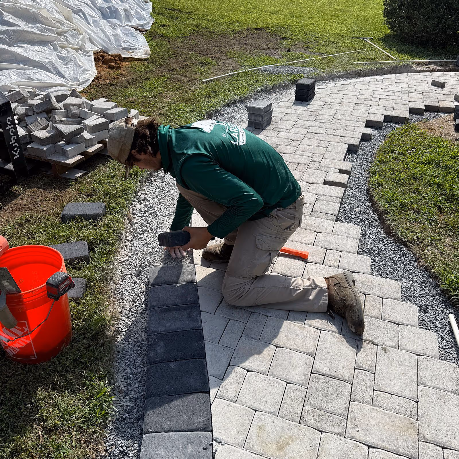 Larsen’s Lawn & Landscape worker installing new patio pavers near me for the best walkways.