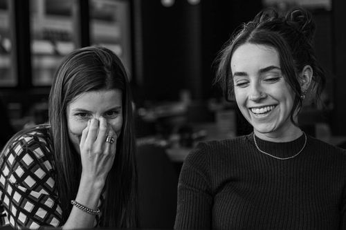 Two female employees smiling and having a nice moment