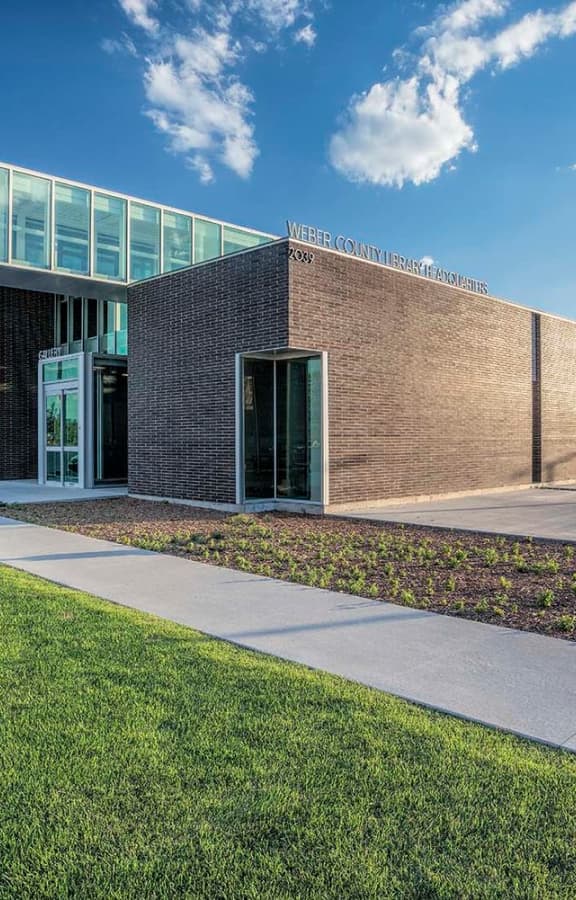 Exterior view of the Weber County Library North Branch building with clear blue sky and green lawn.