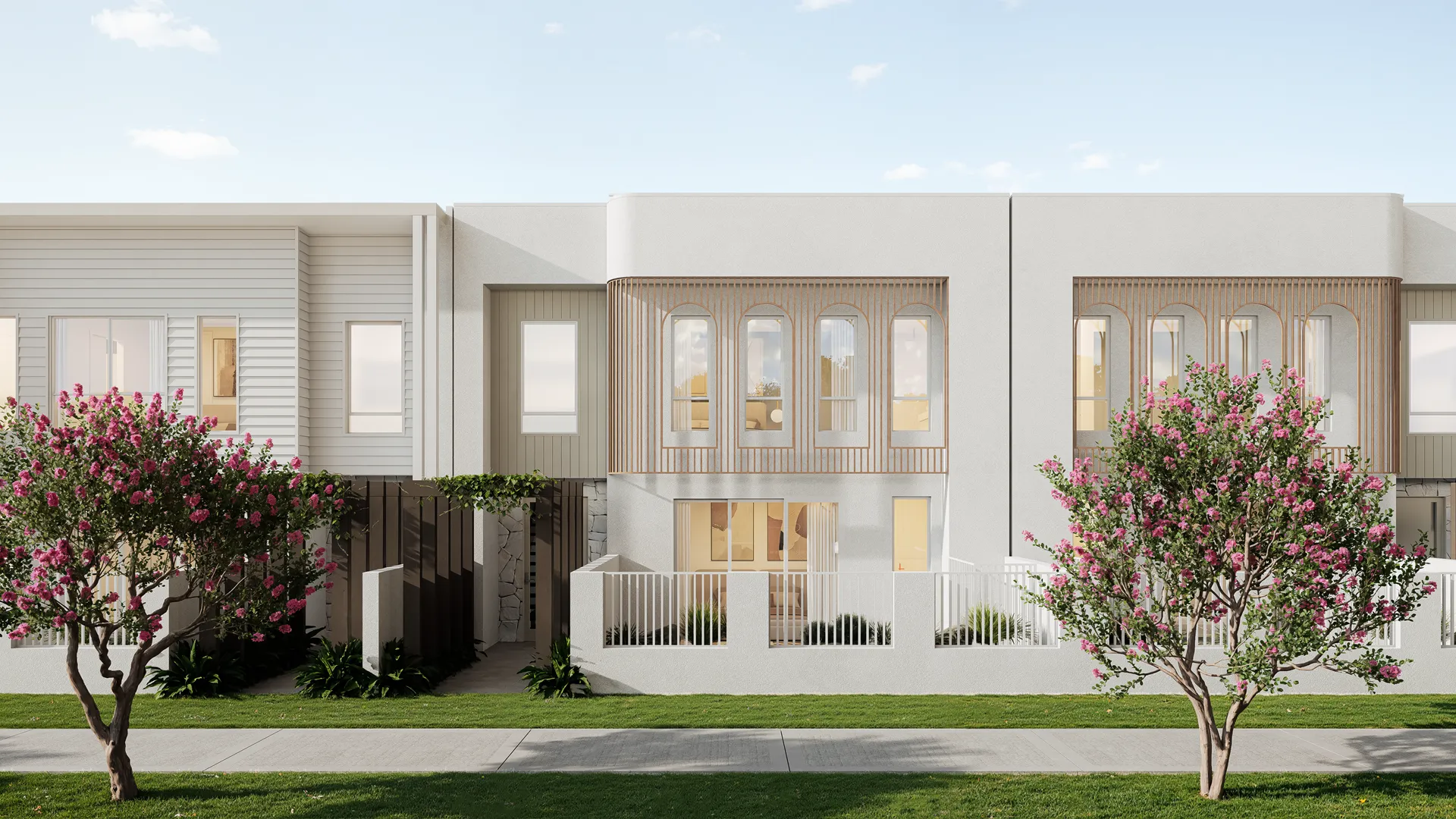 Modern two-story townhouse facade with stone and wood panel accents, large windows, and a front yard with two trees.