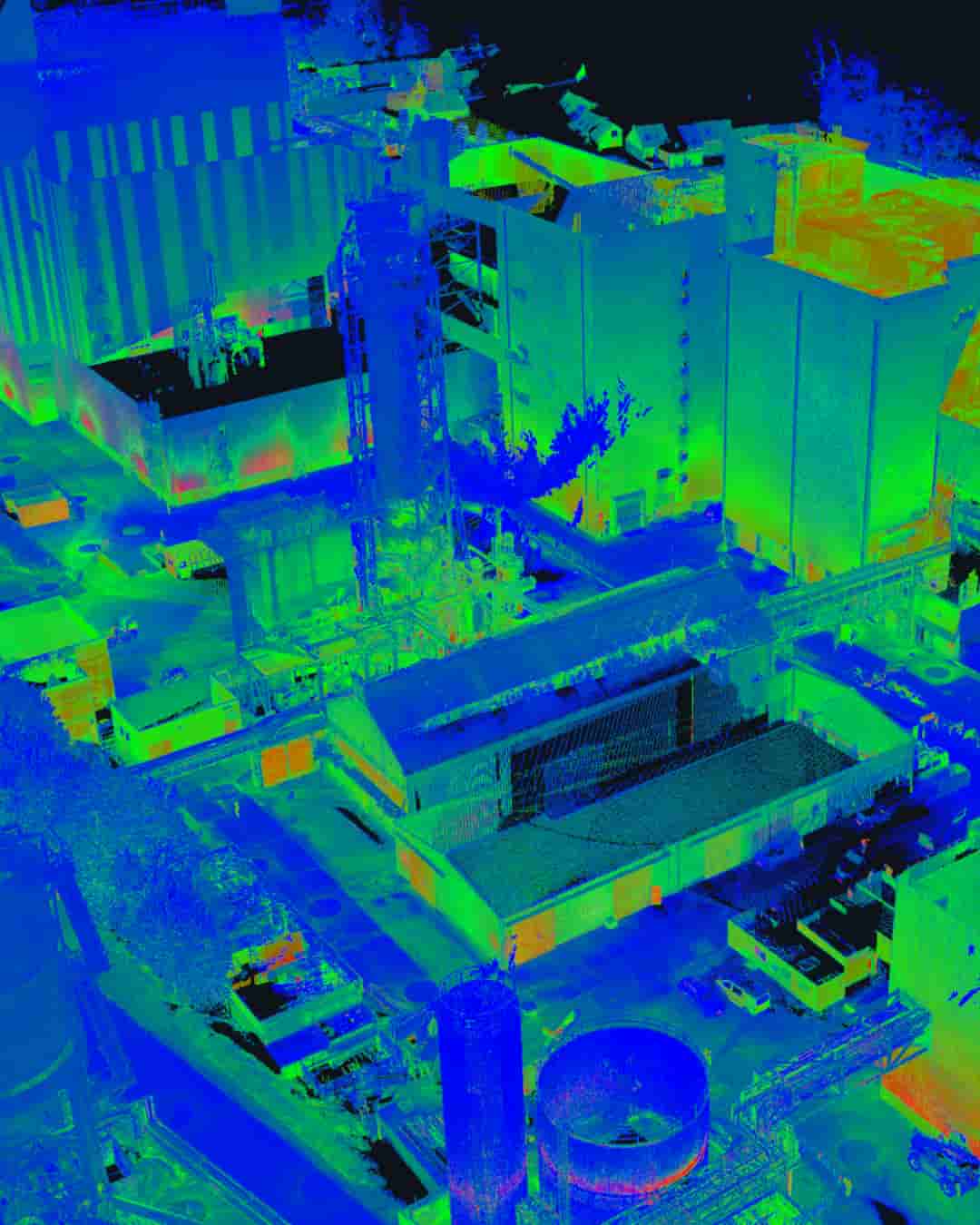 Point cloud scan of an industrial facility with silos, tanks, and multiple buildings in thermal color overlay.