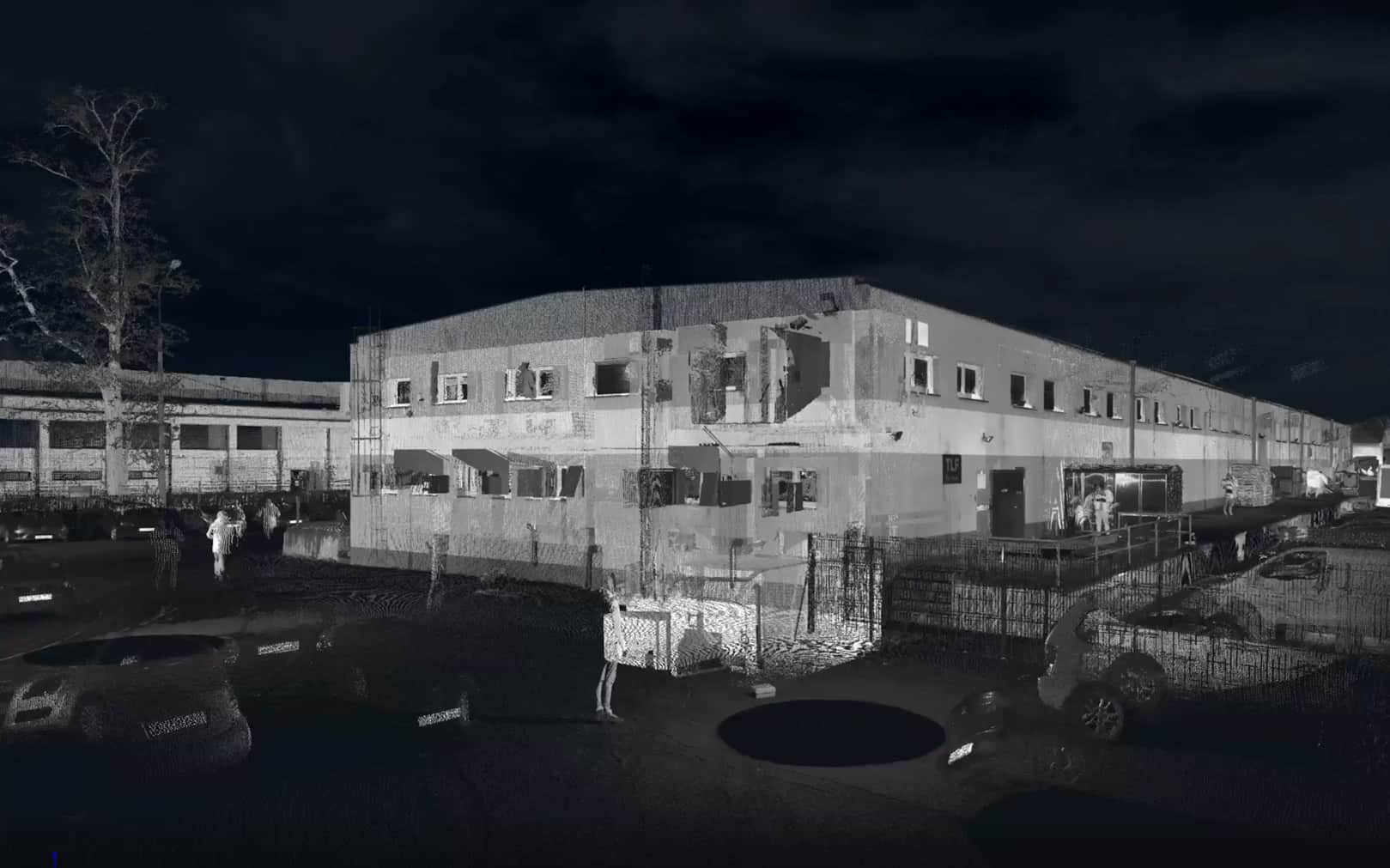 Point cloud scan of an industrial building captured at night, showing structural details and surroundings.